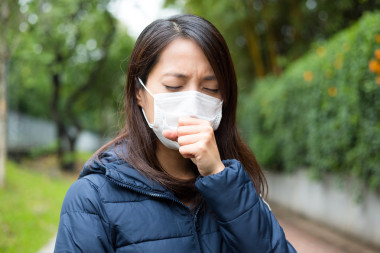 亞洲的年輕女人生病，戴著口罩