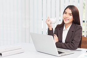 在办公室使用膝上型电脑的年轻的商界女子肖像