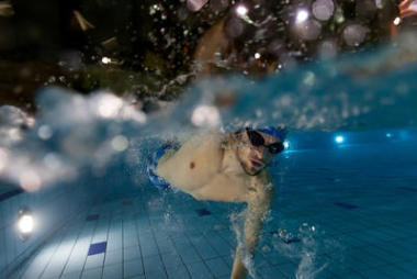 在游泳池中游泳的年輕人