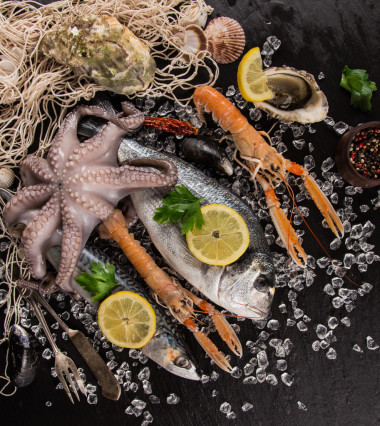 新鮮的海鮮，在黑色的石頭.圖片