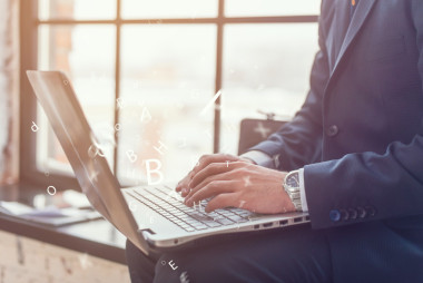 他的筆記本上工作的生意人圖片