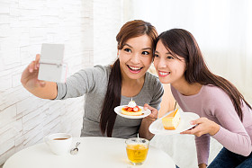 妇女在咖啡馆里拍照片