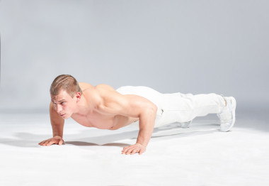 年輕肌肉型男做俯臥撐灰色背景