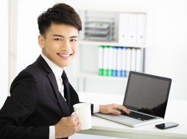 快樂(lè)年輕的商人，在辦公室的筆記本上