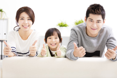 幸福有吸引力的年輕家庭依豎起大拇指