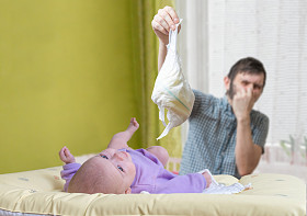 父亲改变臭尿布。婴儿腹泻的护理