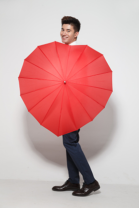 青年男人拿着心形红雨伞照片