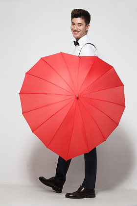 青年男人拿着心形红雨伞图片