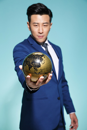 青年商务男人拿着地球仪图片