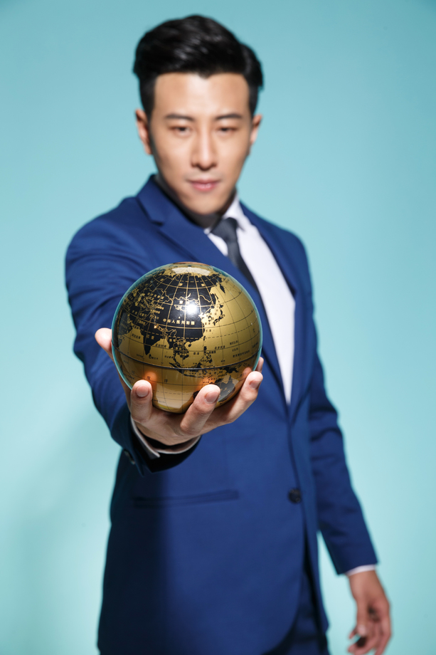 青年商务男人拿着地球仪图片