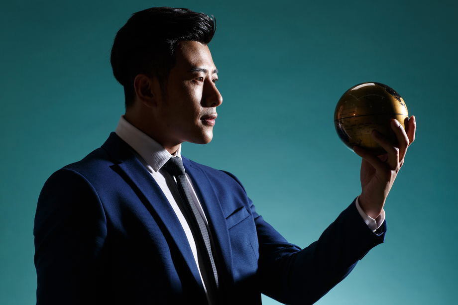 青年商务男人拿着地球仪