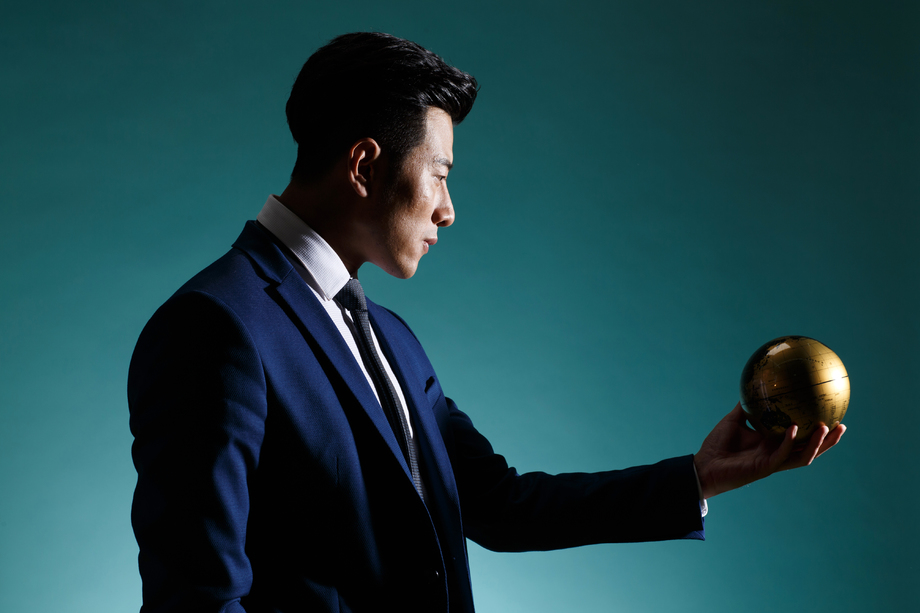 青年商务男人拿着地球仪