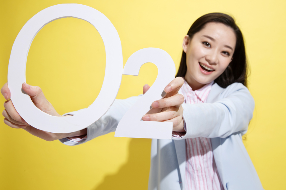 时尚青年女人拿着氧气符号 时尚青年女人拿着氧气符号