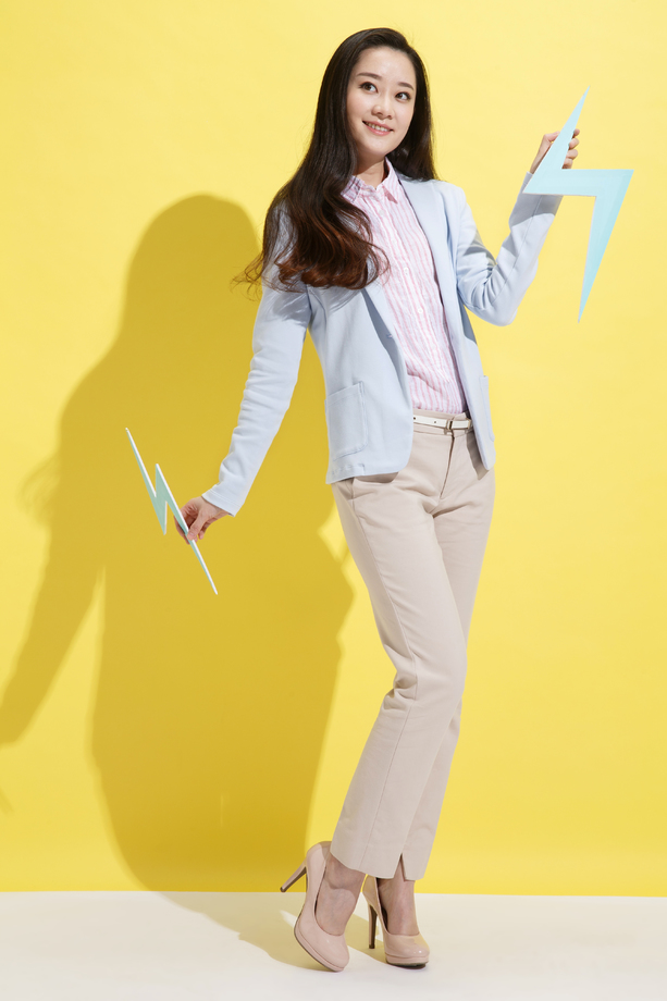 青年商务女士拿着闪电符号 青年商务女士拿着闪电符号