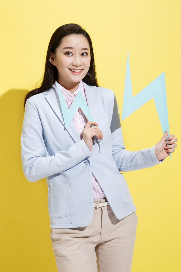 青年商务女士拿着闪电符号 青年商务女士拿着闪电符号