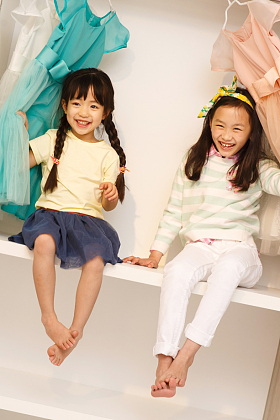 可爱的小女孩坐在衣柜里照片