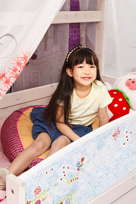 可爱的小女孩在床上玩耍图片