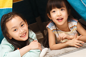 可爱的小女孩在帐篷里玩耍照片