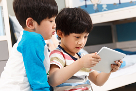 两个男孩在使用平板电脑图片