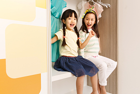 可爱的小女孩坐在衣柜里照片