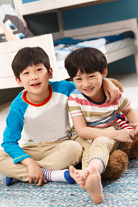 两个男孩坐在卧室的地毯上图片