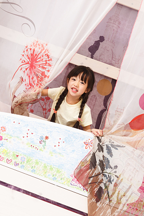 可爱的小女孩在床上玩耍图片