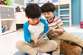 两个男孩在使用平板电脑照片