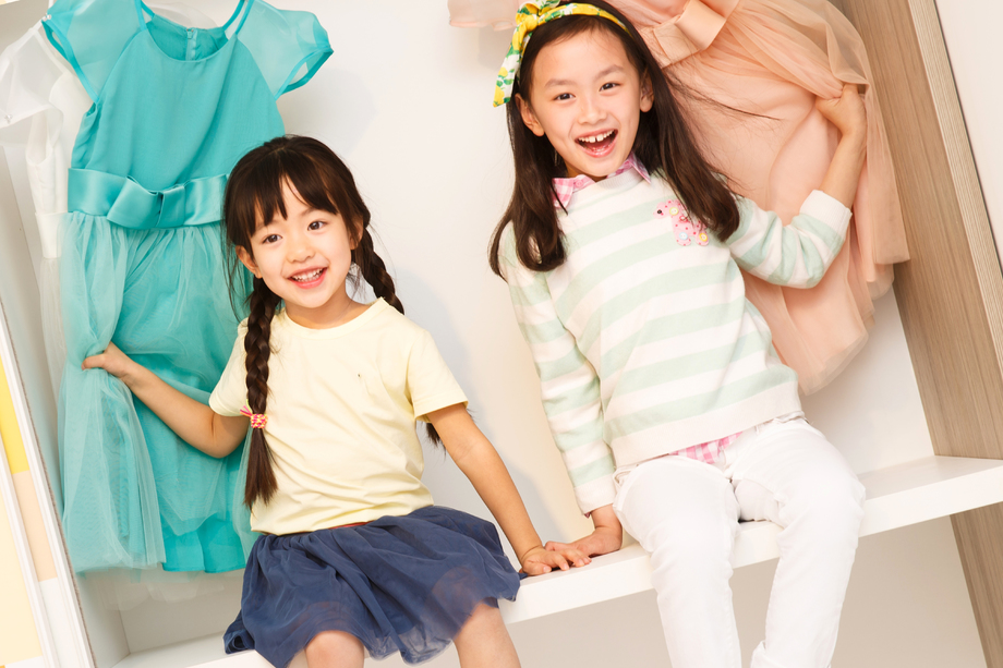 可爱的小女孩坐在衣柜 可爱的小女孩坐在衣柜