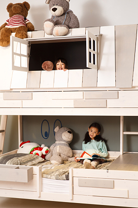 可爱的小女孩在床上玩耍照片