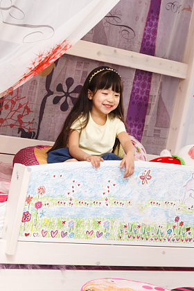 可爱的小女孩在床上玩耍图片