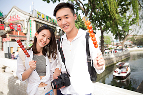青年情侣旅游拿着糖葫芦图片