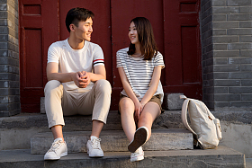 青年情侣坐在门口交谈照片