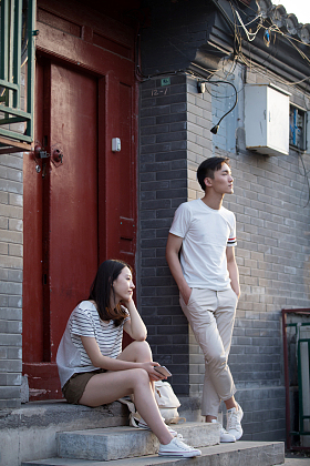 青年情侣坐在门口交谈照片