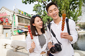 青年情侣旅游拿着糖葫芦图片