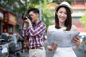 青年女人拿着地图旅行照片