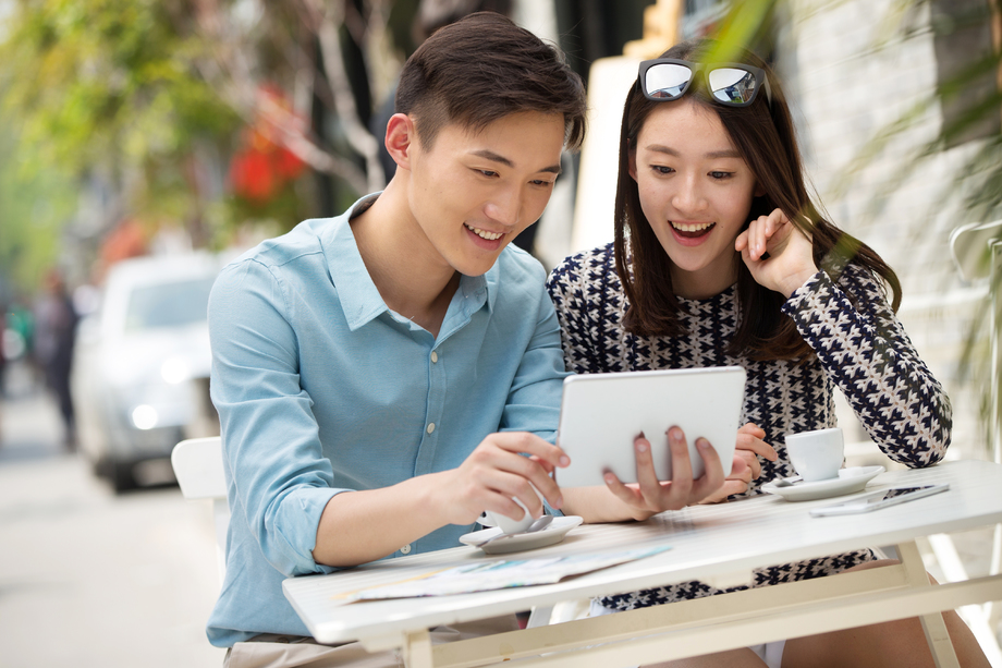 青年情侣坐在咖啡馆看平板电脑 青年情侣坐在咖啡馆看平板电脑