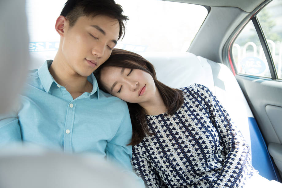 青年情侣坐在车里睡觉