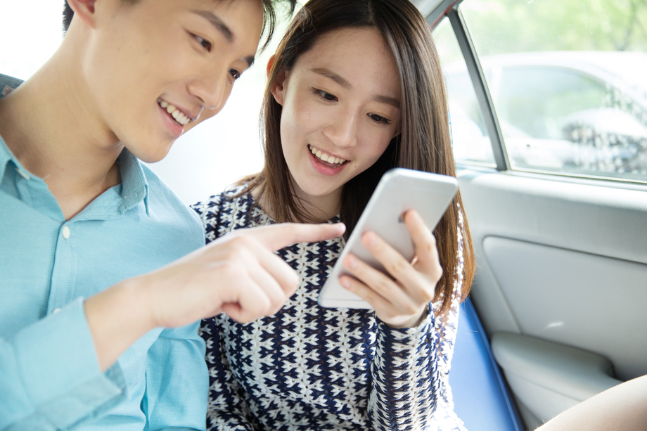 青年情侣在车内看手机 青年情侣在车内看手机