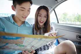 青年情侣在车内看地图