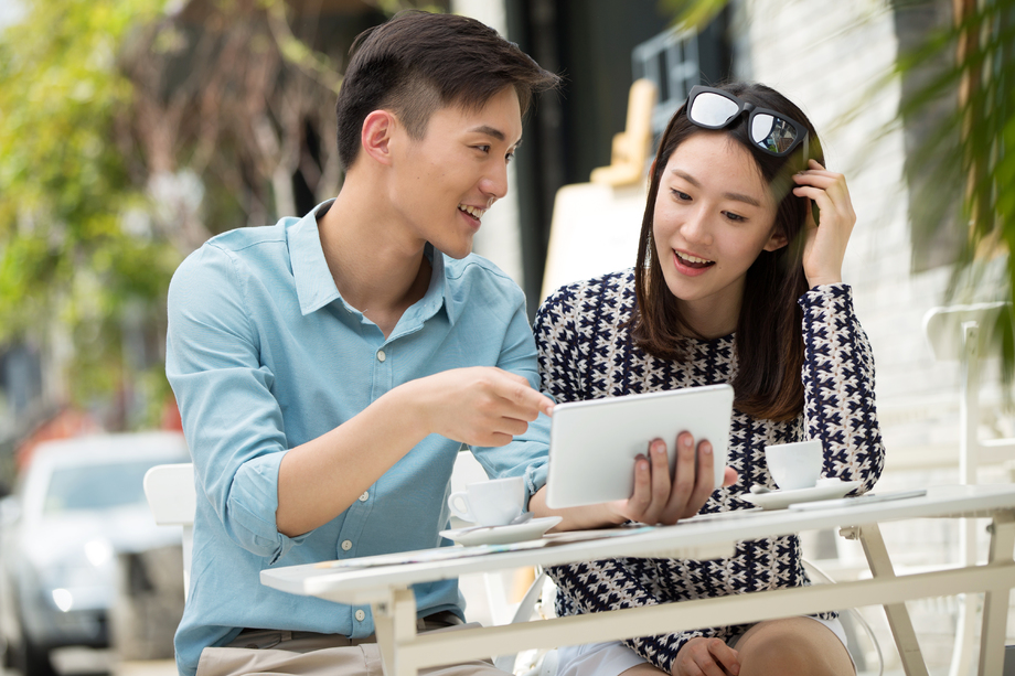 青年情侣坐在咖啡馆看平板电脑 青年情侣坐在咖啡馆看平板电脑