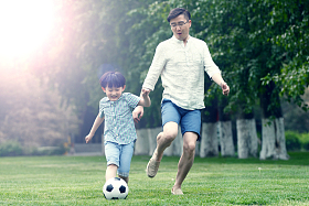 快乐父子在草地上踢足球图片