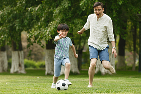 快乐父子在草地上踢足球图片