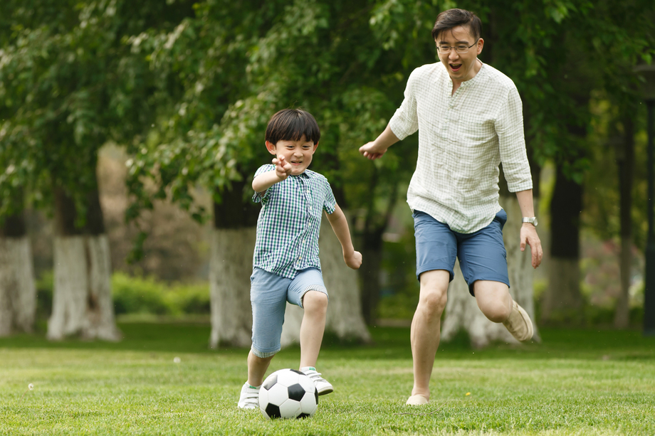 快乐父子在草地上踢足球图片 快乐父子在草地上踢足球图片