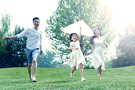 一家三口在草地上放风筝照片