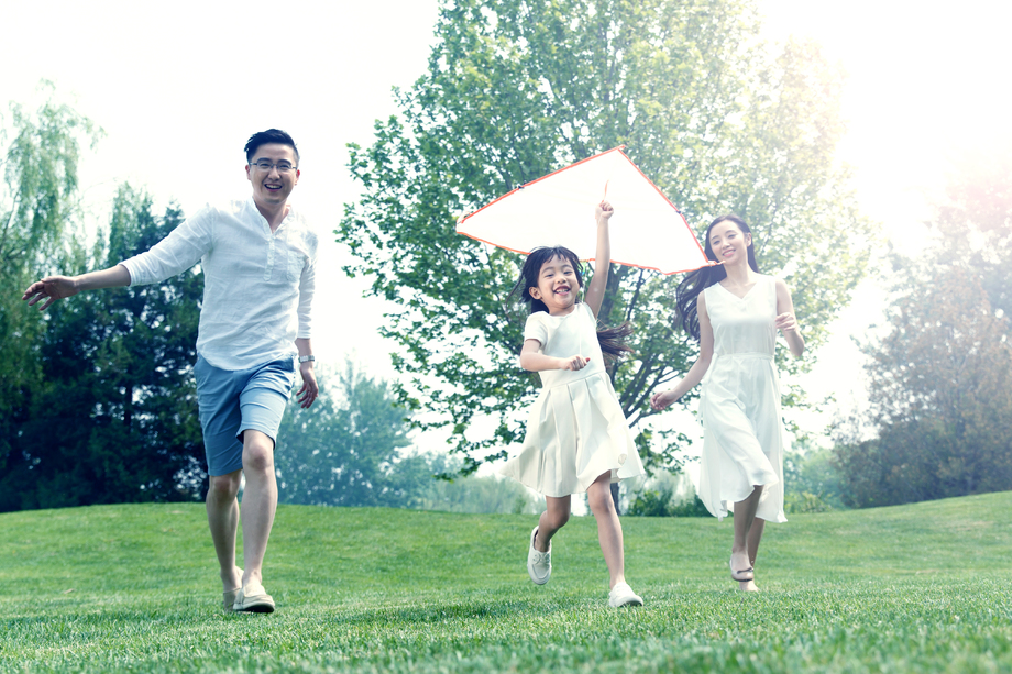 一家三口在草地上放风筝照片