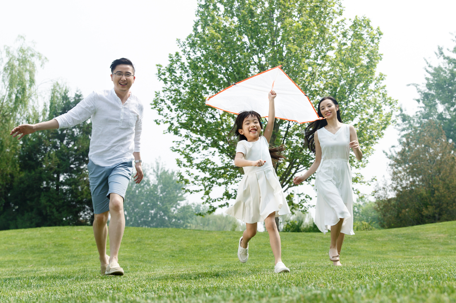 一家三口在草地上放风筝照片