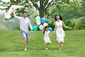 一家三口在草地上放风筝照片