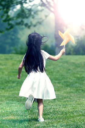 小女孩在草地上玩耍图片