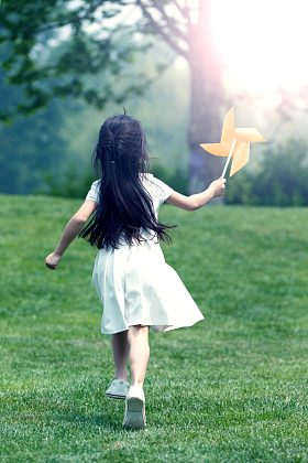 小女孩在草地上玩耍照片