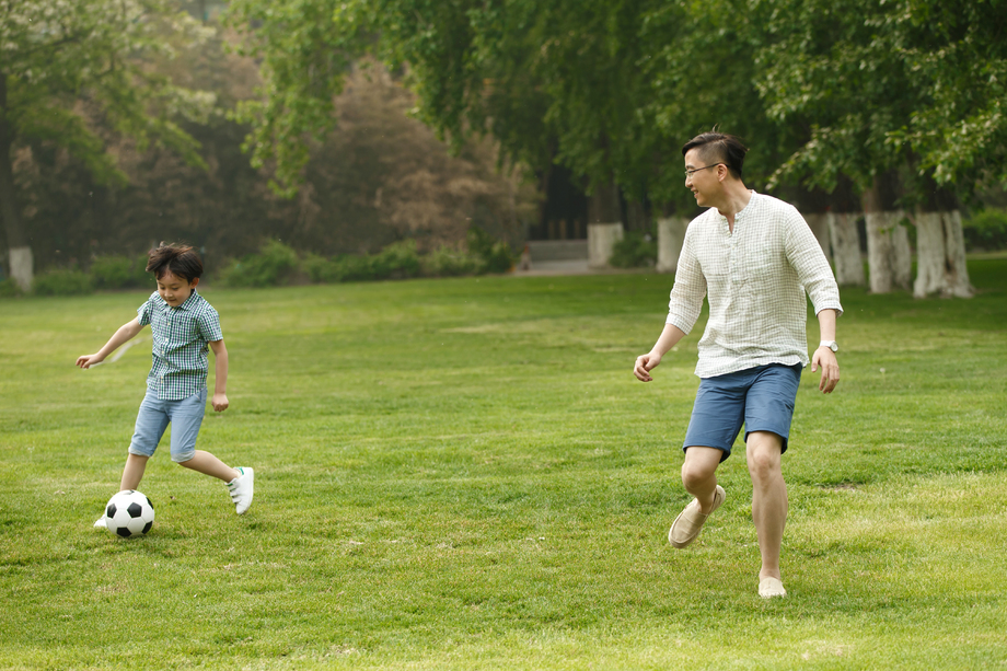 快乐父子在草地上踢足球图片 快乐父子在草地上踢足球图片